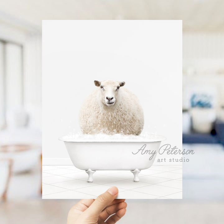 a hand holding a card with a sheep in a bathtub