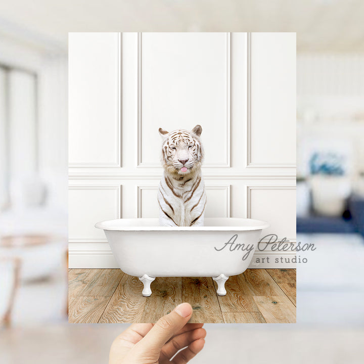 a hand holding a photo of a white tiger in a bathtub