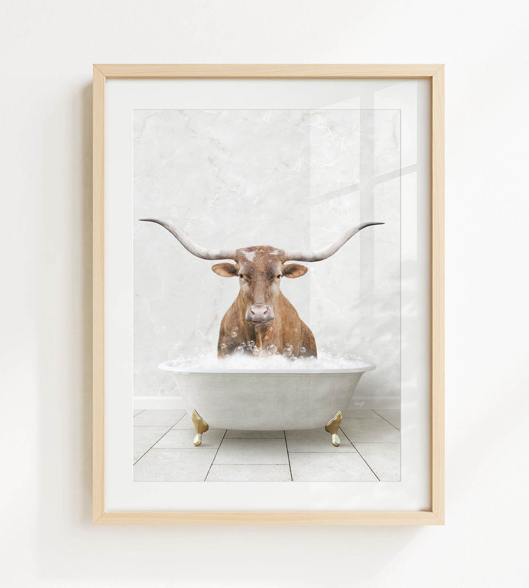 A framed image depicting a brown cow with long horns sitting in a white bathtub filled with water.