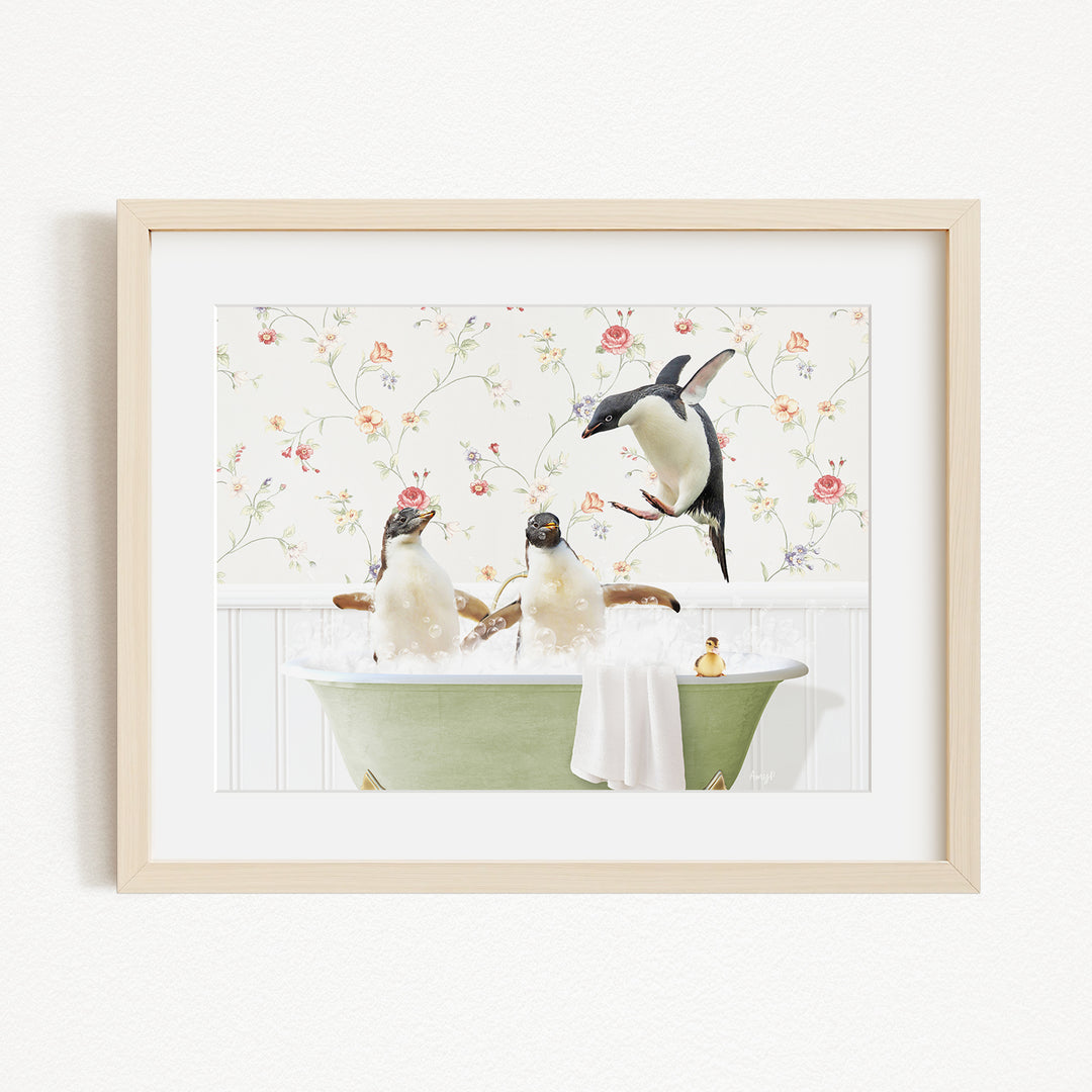 A framed image depicting three penguins sitting in a green bathtub, with a floral wallpaper in the background.
