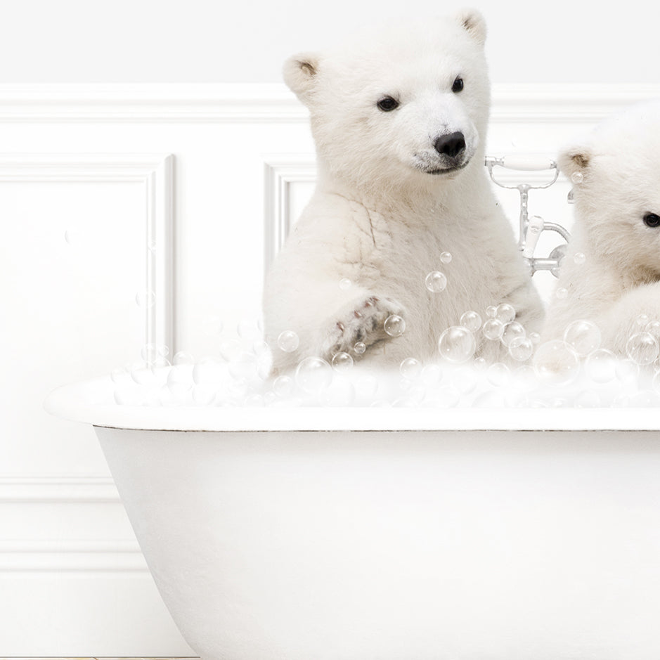 two white polar bears sitting in a bathtub