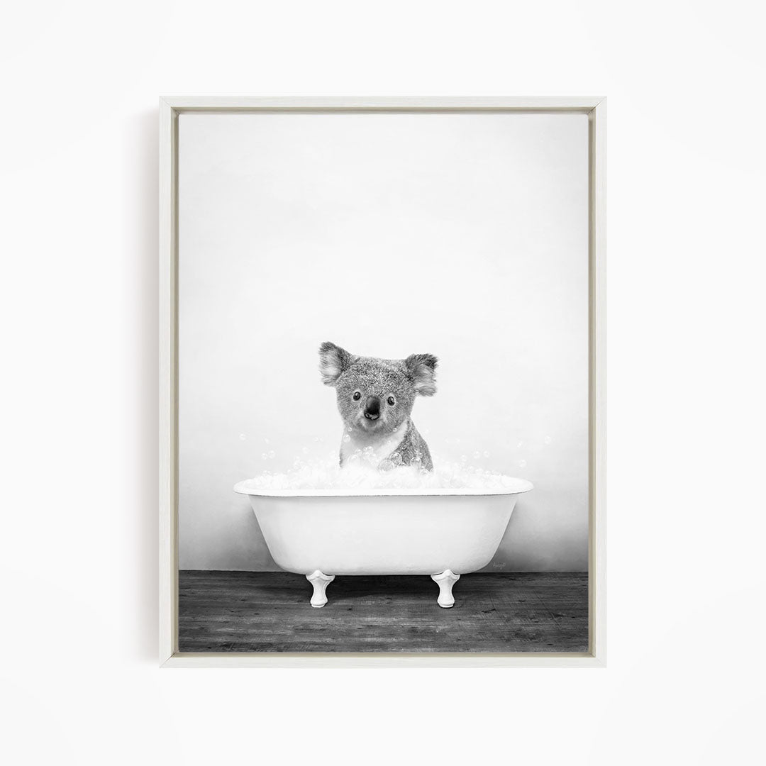 A koala sitting in a bathtub filled with water, looking directly at the camera.