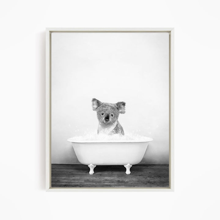 A koala sitting in a bathtub filled with water, looking directly at the camera.