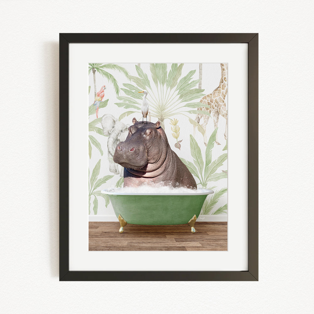 A framed image depicting a hippopotamus sitting in a green bathtub, surrounded by tropical foliage and a bird.