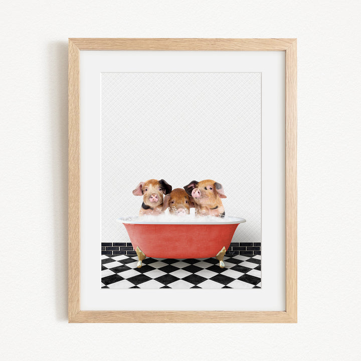 Three adorable pigs sitting in a red bathtub on a black and white checkered floor.