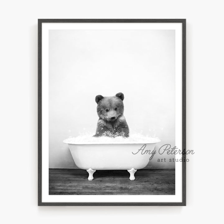 a black and white photo of a bear in a bathtub