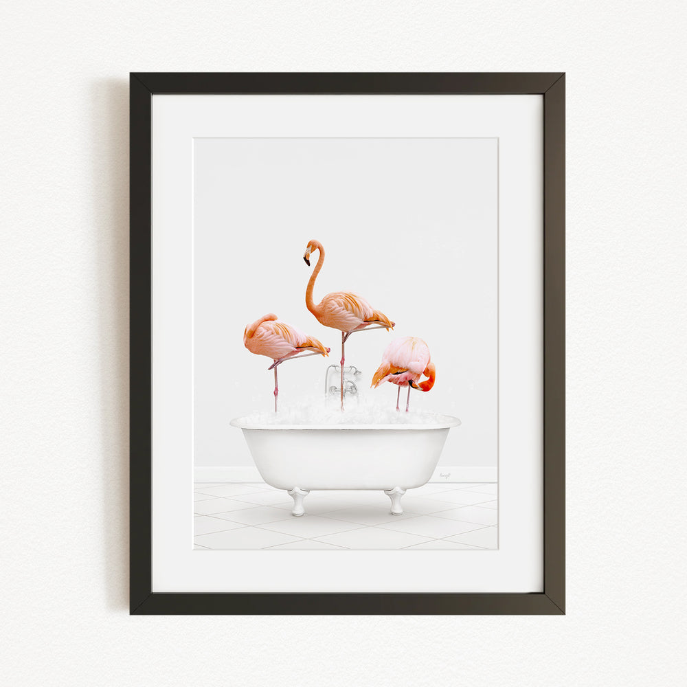 A framed image depicting three flamingos standing in a white bathtub filled with water.