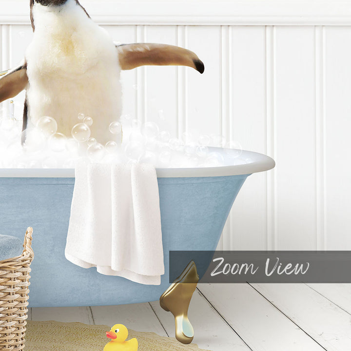 A penguin standing in a blue bathtub filled with bubbles, with a towel and rubber duck nearby.