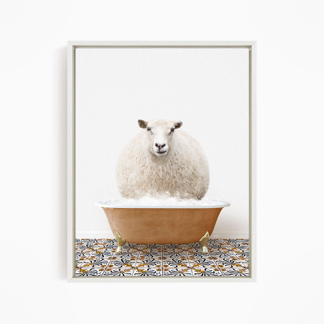 A fluffy white sheep sits in a bathtub filled with bubbles, looking directly at the camera.