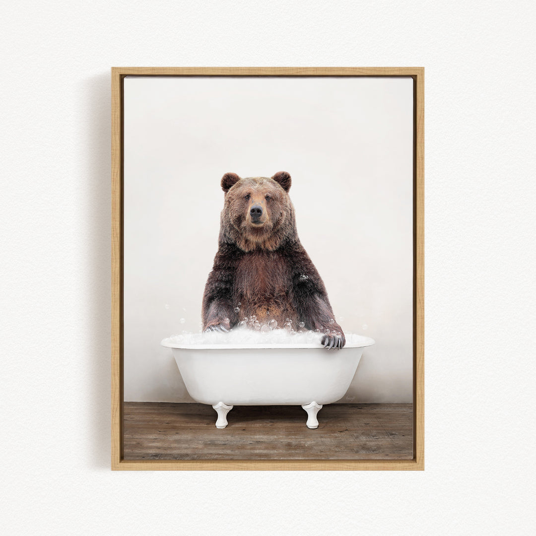A brown bear sitting in a white bathtub filled with water, appearing to enjoy the bath.