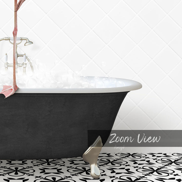 a black claw-foot bathtub filled with water, with a white tiled wall in the background.
