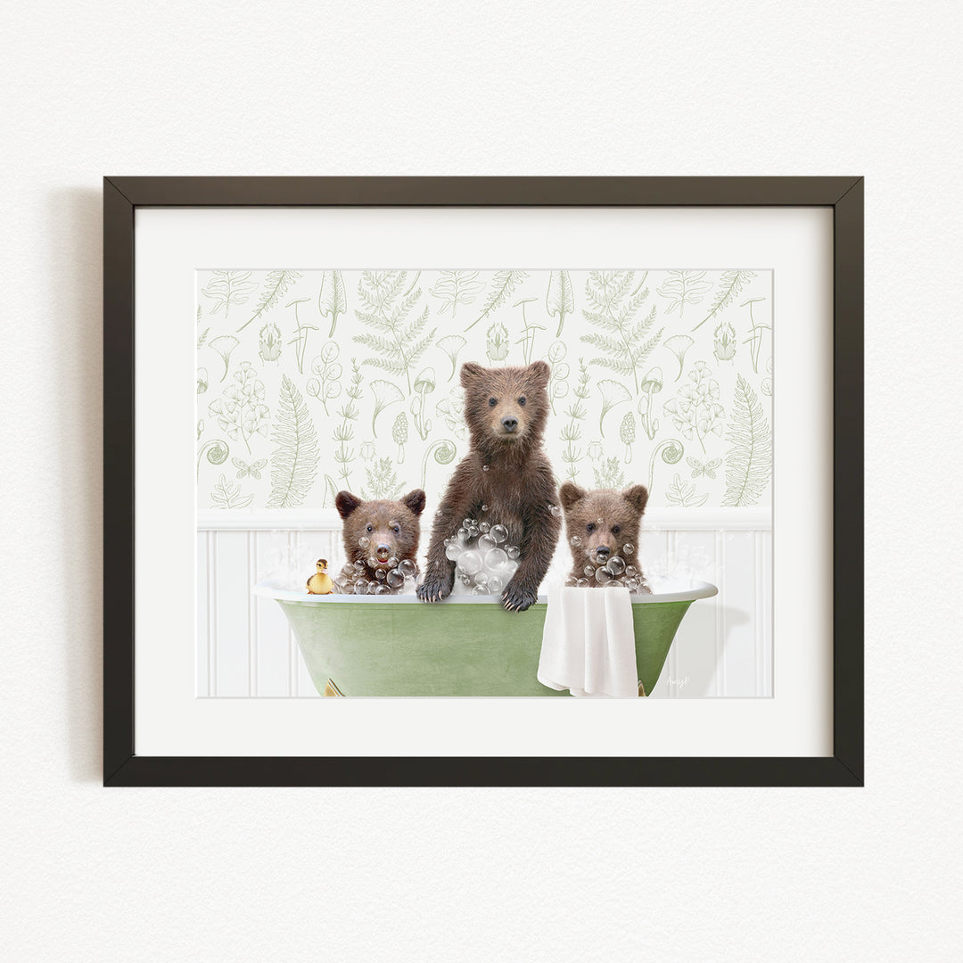 A framed image depicting three bears sitting in a green bathtub, with one bear sitting on the edge of the tub and the other two bears sitting inside the tub.