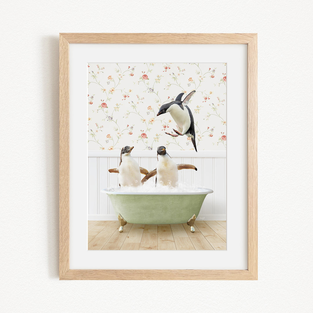 A framed image depicting two penguins sitting in a green bathtub, with one penguin flying towards the other.