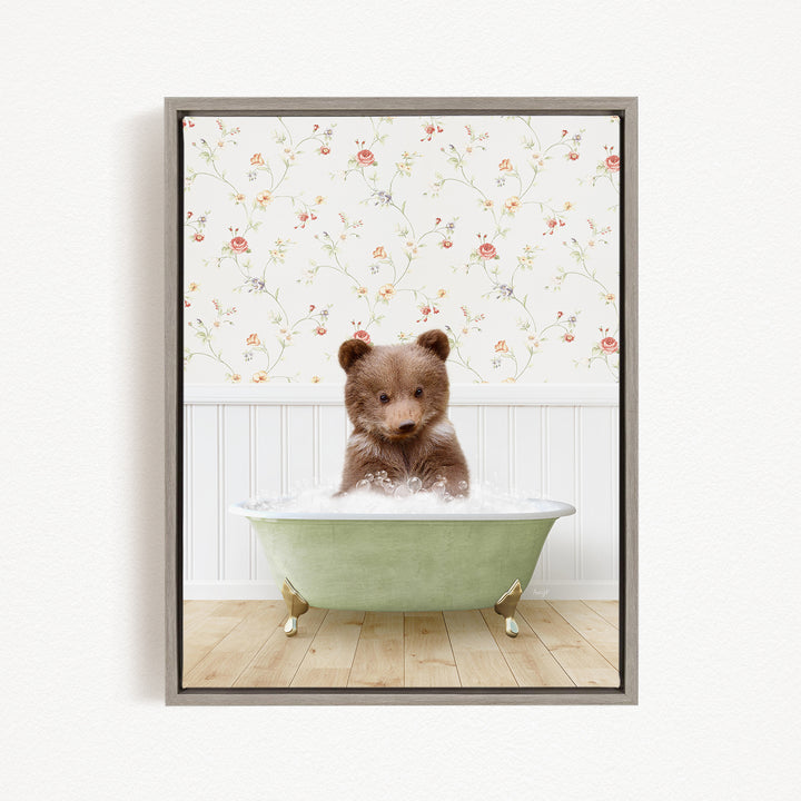 A brown bear sitting in a green bathtub filled with water, with a floral wallpaper in the background.