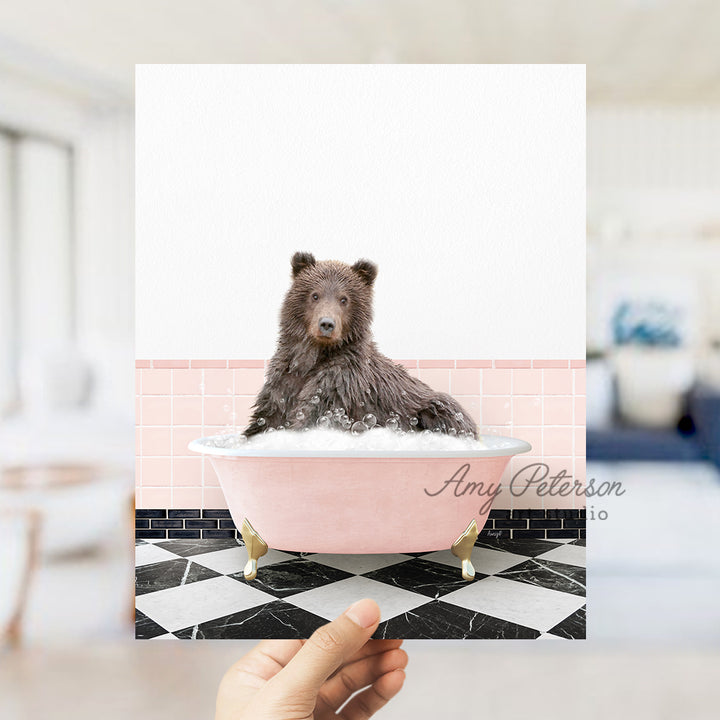 a hand holding up a card with a picture of a bear in a bathtub