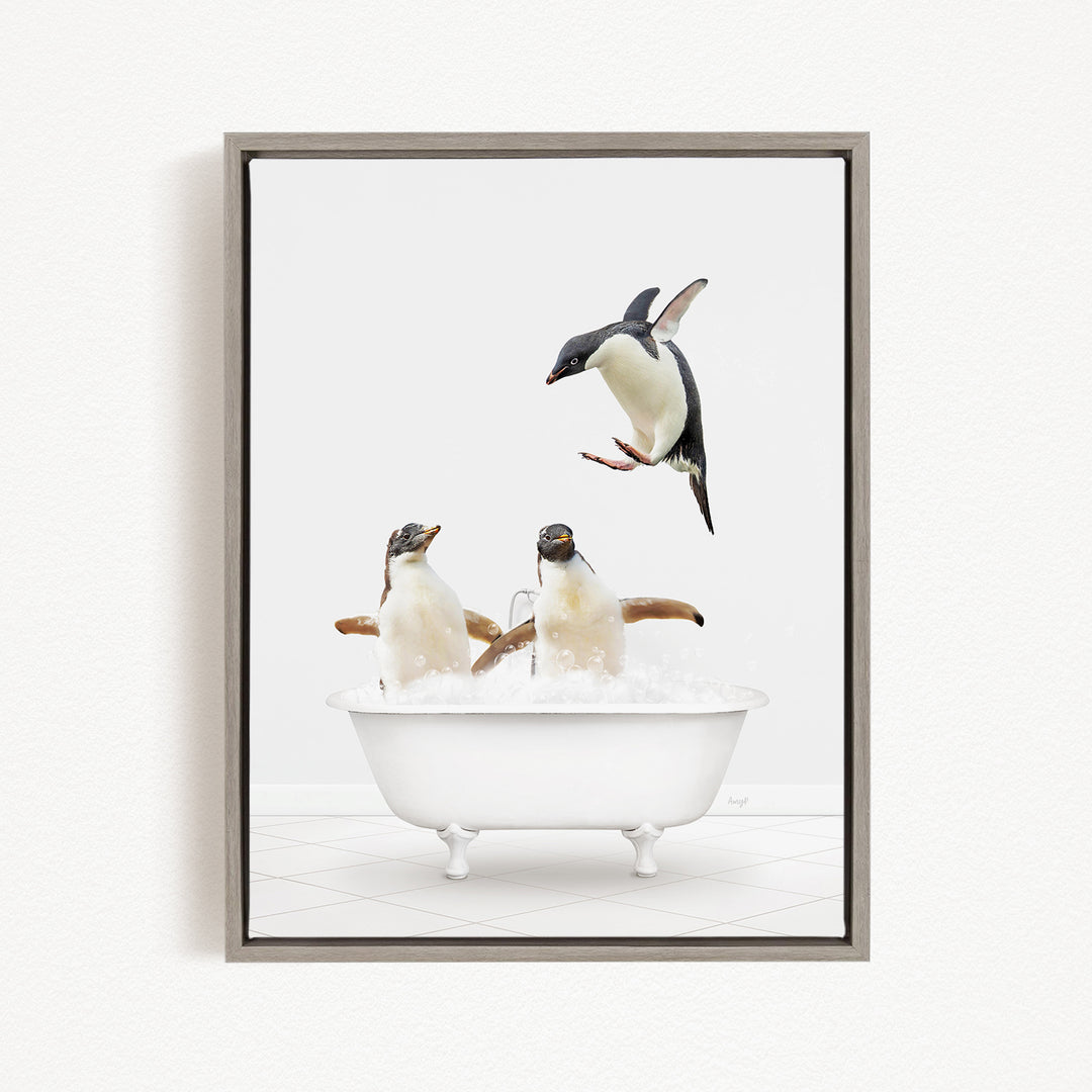 A framed image depicting two penguins sitting in a bathtub, with one penguin jumping out of the tub.