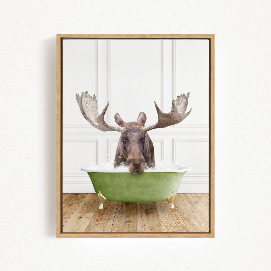 A moose with large antlers is sitting in a green bathtub filled with water, creating a whimsical and humorous scene.