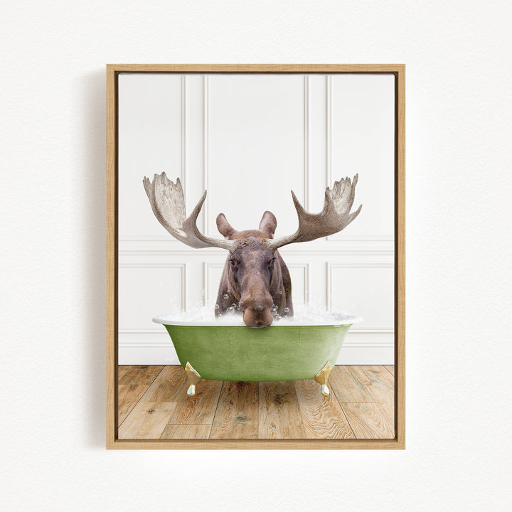 A moose with large antlers is sitting in a green bathtub filled with water, creating a whimsical and humorous scene.