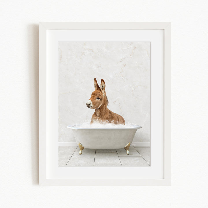 A donkey is sitting in a white bathtub filled with bubbles, creating a whimsical and playful scene.