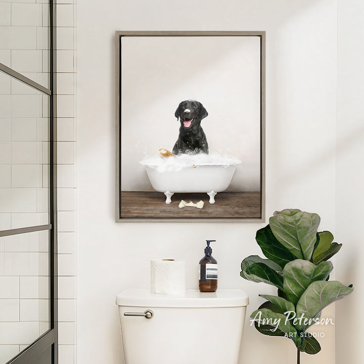 A framed image of a black dog sitting in a bathtub filled with bubbles, surrounded by a potted plant and toiletries in a bathroom setting.
