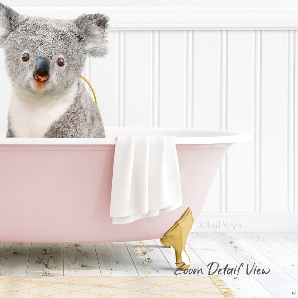 A koala bear sitting in a pink bathtub, with a towel and gold bathtub leg visible.