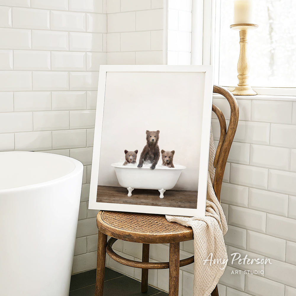 A framed photograph of three bears sitting in a bathtub, with one bear sitting in the center and the other two bears sitting on either side.