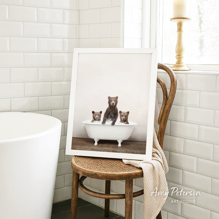 A framed photograph of three bears sitting in a bathtub, with one bear sitting in the center and the other two bears sitting on either side.