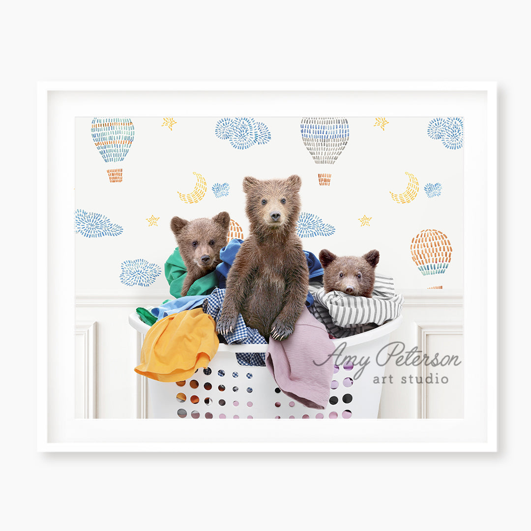 a group of three bears sitting on top of a laundry basket