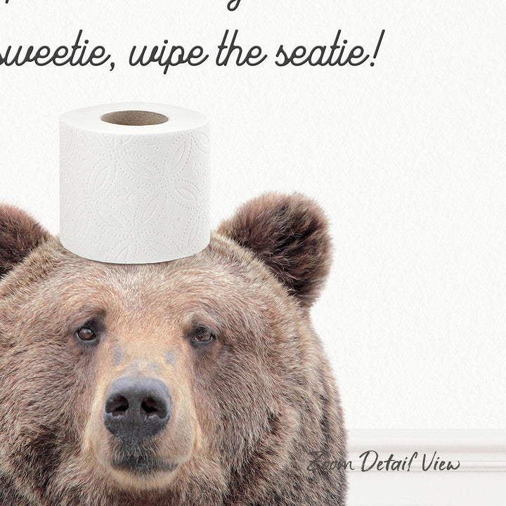 A close-up of a brown bear with a roll of toilet paper on its head, accompanied by the text "Sweetie, wipe the seatie!"