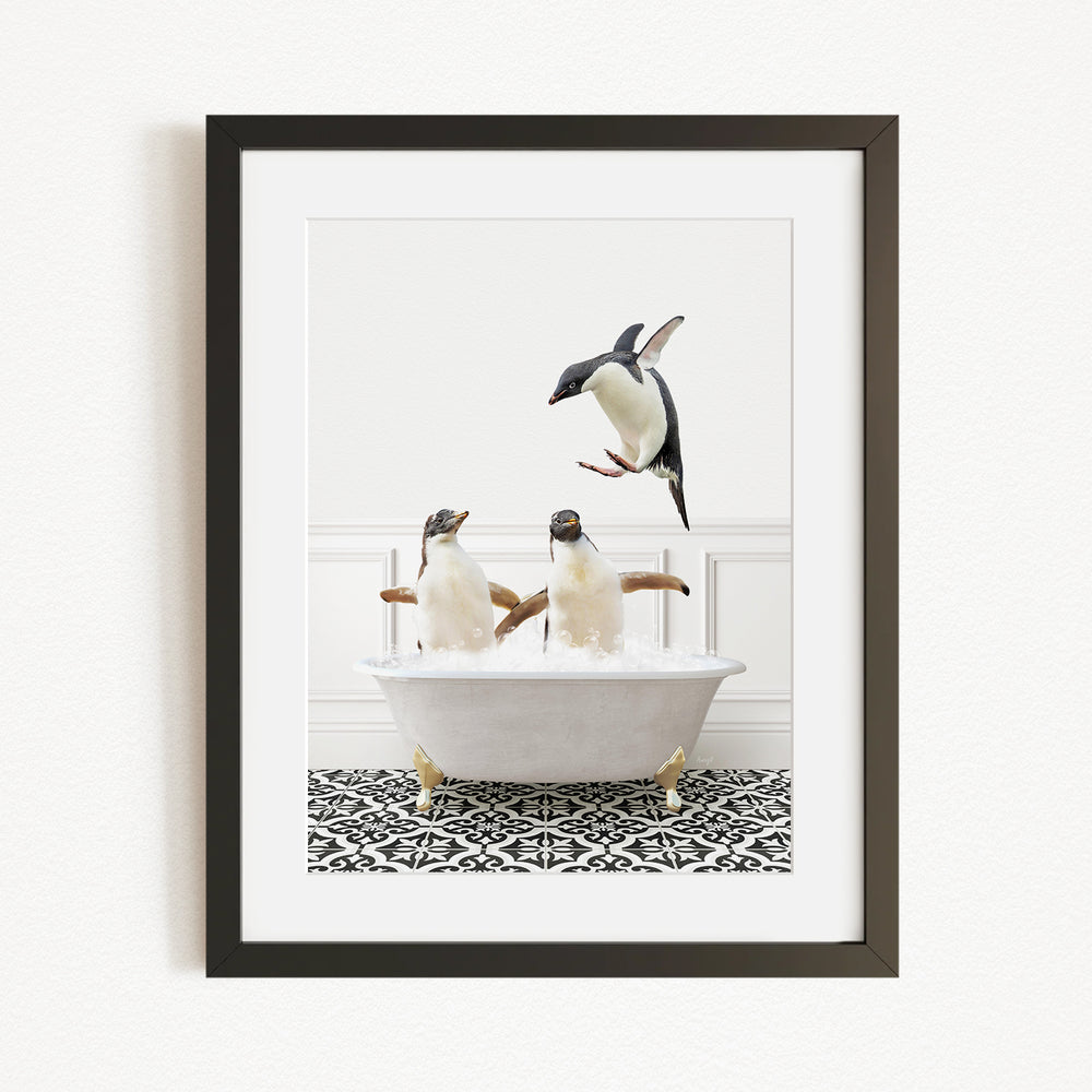 A framed image depicting two penguins sitting in a bathtub, with one penguin flying towards the other.