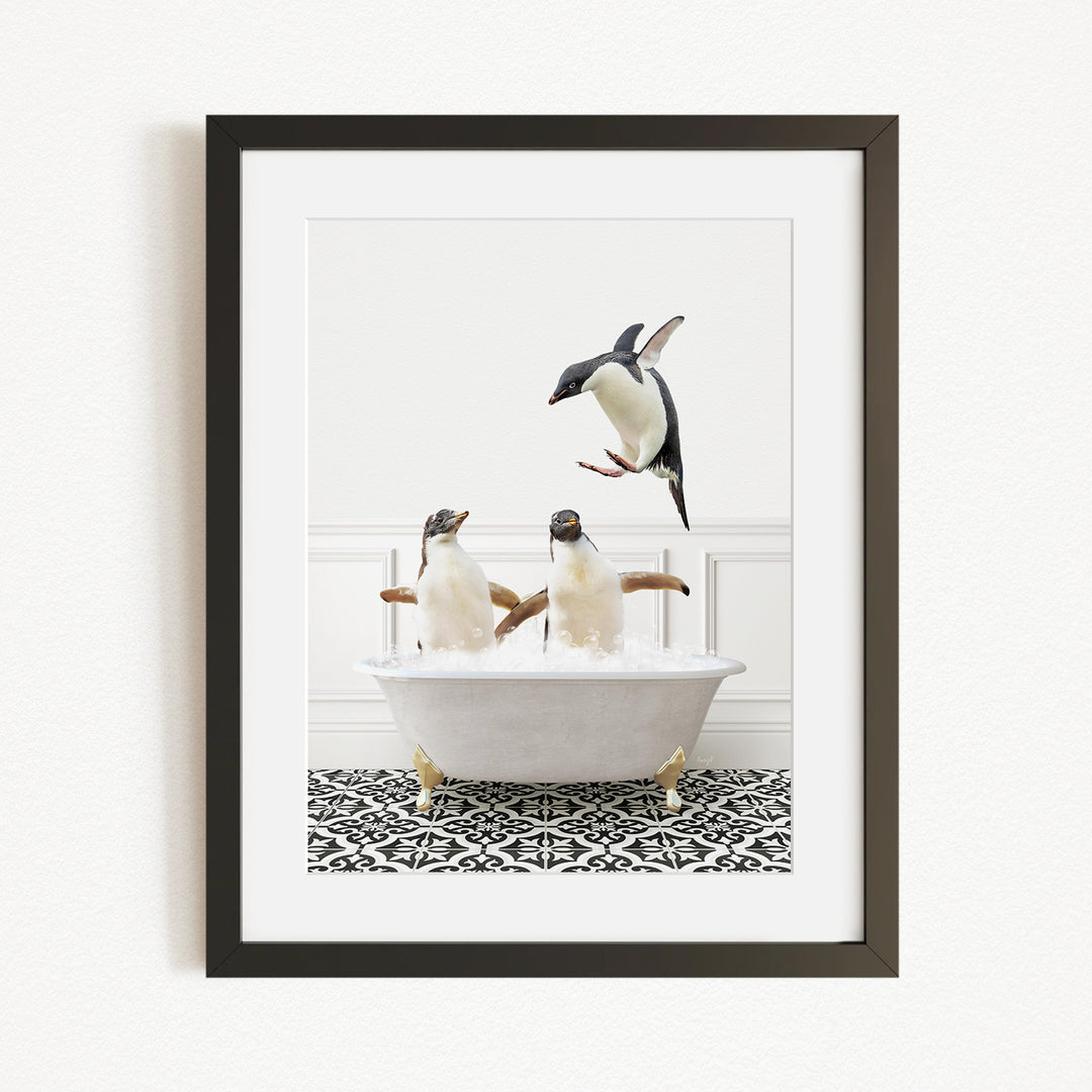 A framed image depicting two penguins sitting in a bathtub, with one penguin flying towards the other.