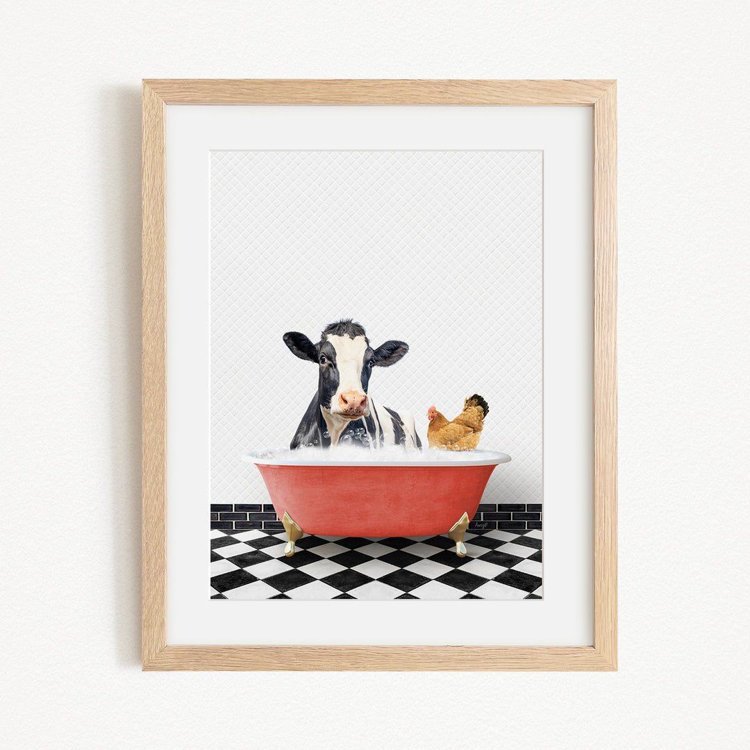 A framed image depicting a cow and a chicken relaxing in a red bathtub filled with water, set against a black and white checkered floor.