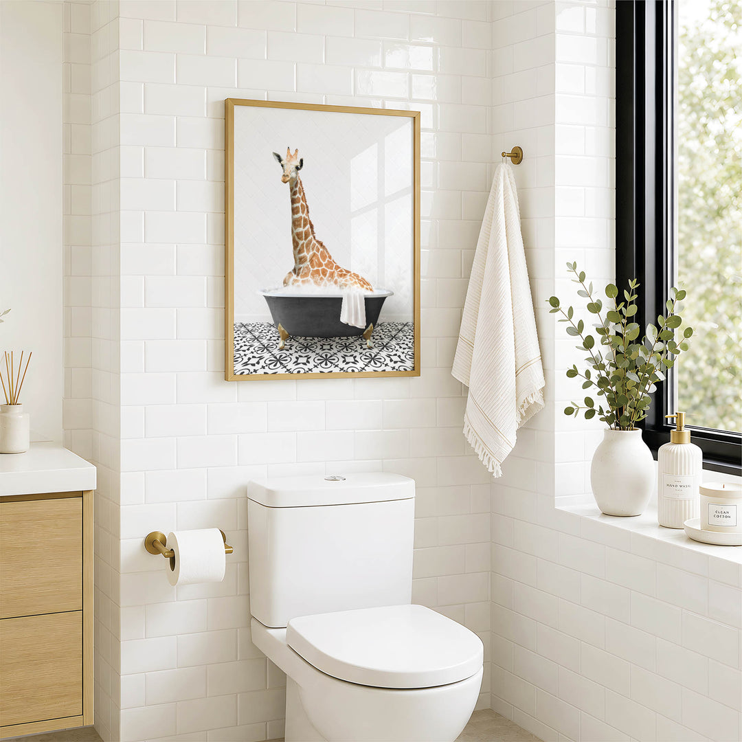 A bathroom with a white toilet, a framed picture of a giraffe in a bathtub, and a window with greenery on the sill.