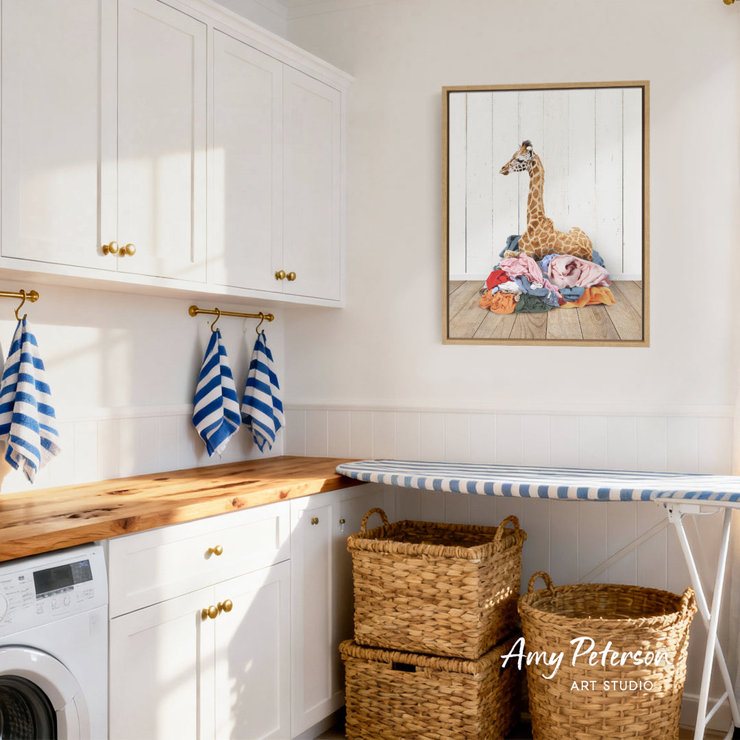 a well-organized laundry room with white cabinets, a wooden countertop, and a framed painting of a giraffe on the wall.