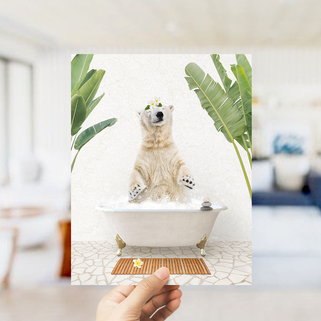 A polar bear sitting in a bathtub filled with water, surrounded by tropical plants, with a hand holding up the image.