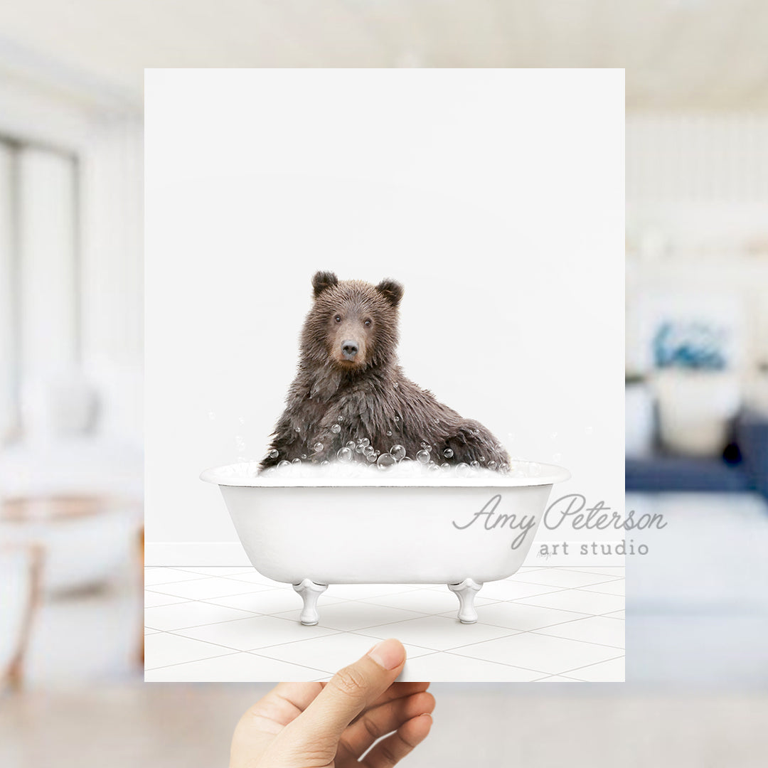 a hand holding up a card with a bear in a bathtub