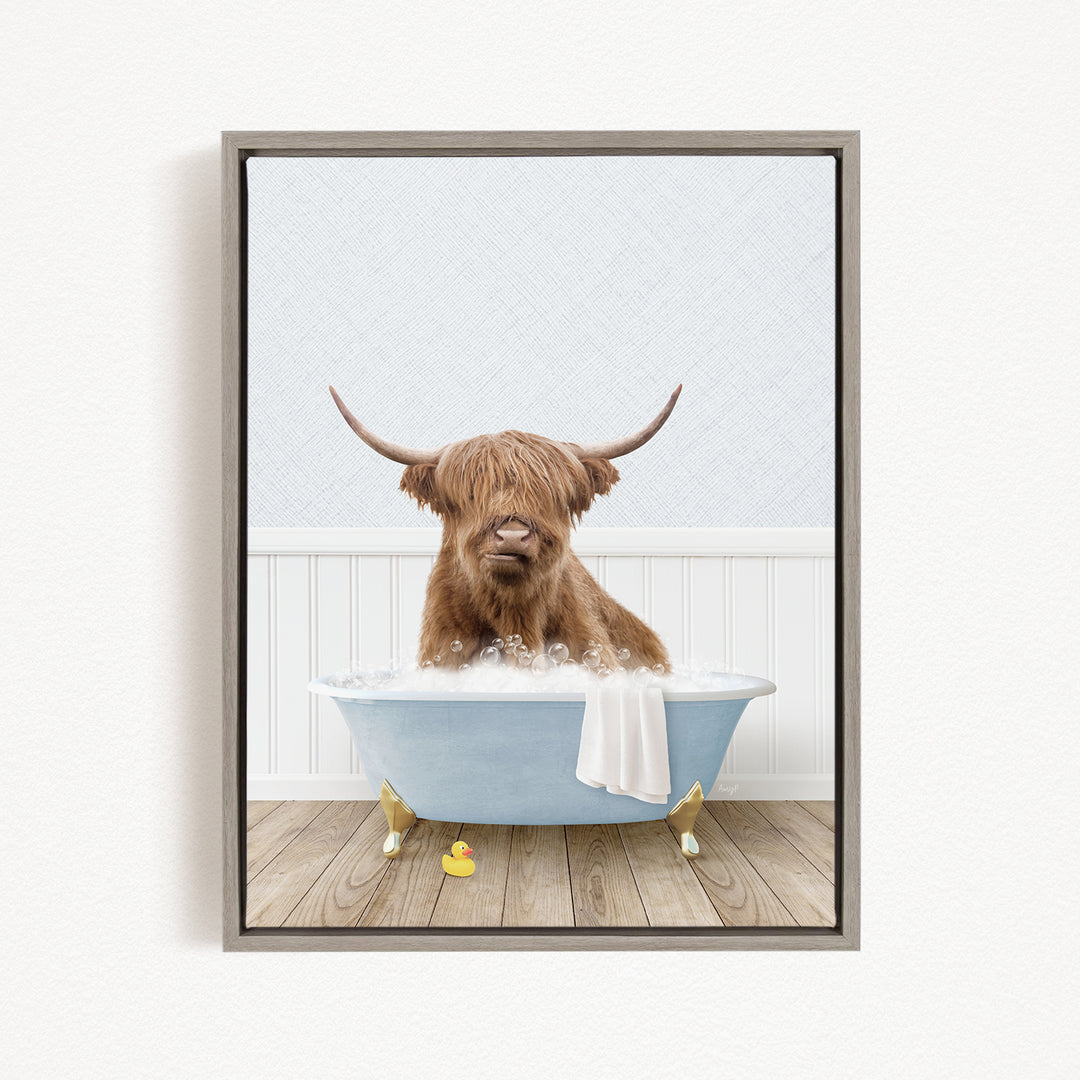 A brown cow with long horns is sitting in a blue bathtub, surrounded by yellow rubber duckies.
