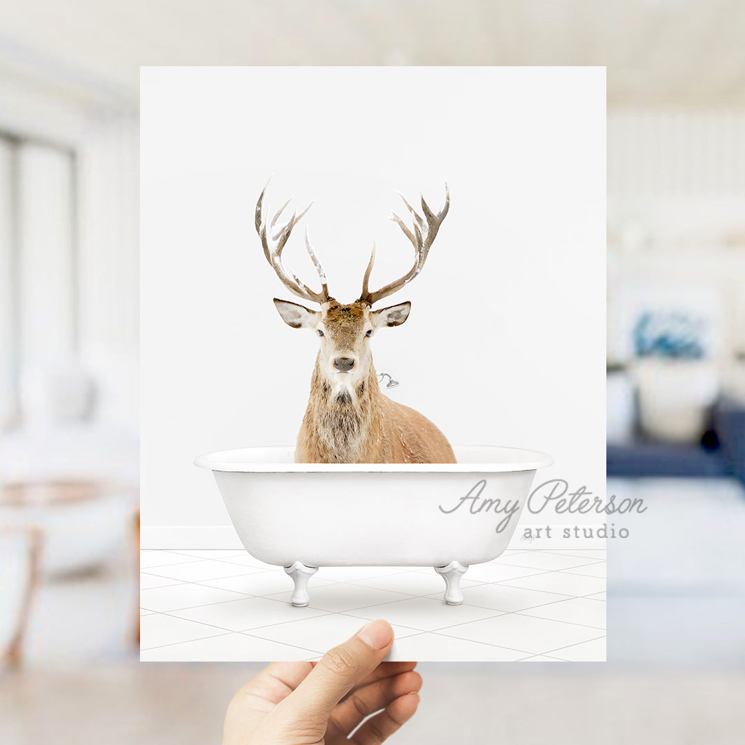 a hand holding up a photo of a deer in a bathtub