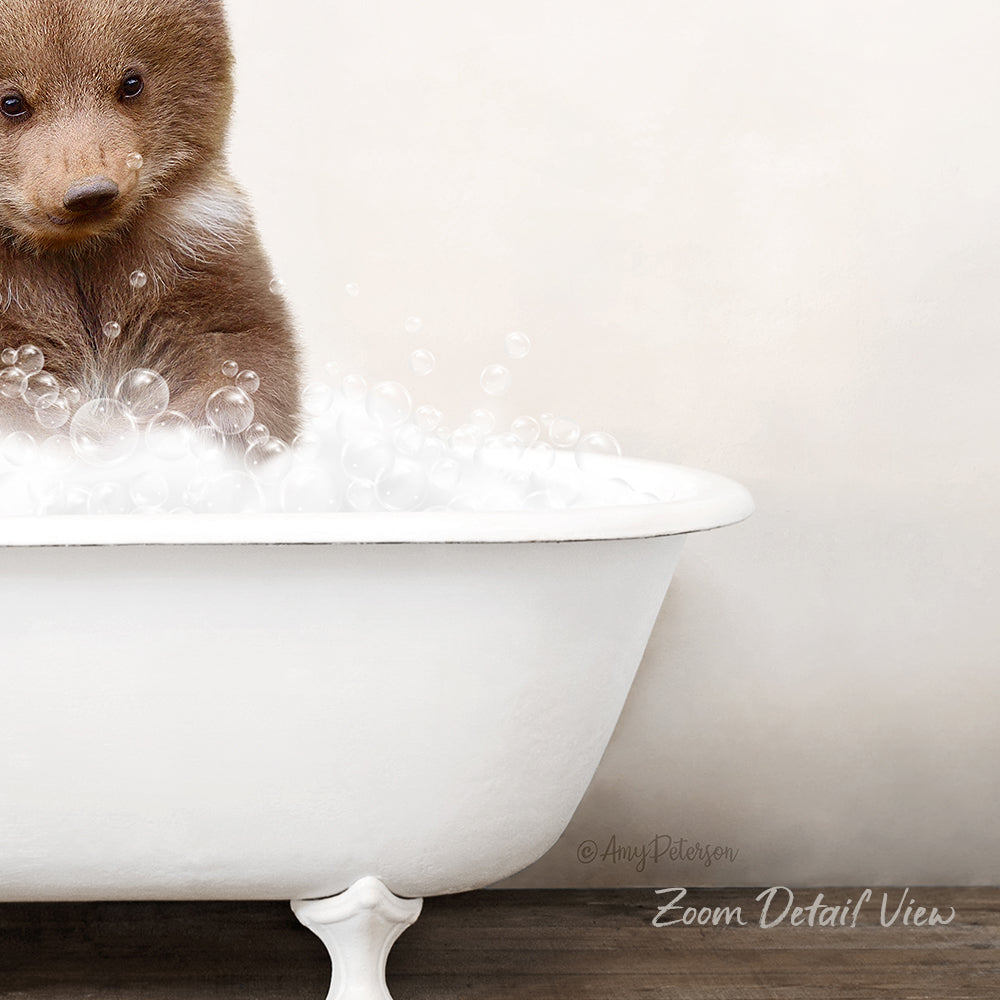 A cute brown bear cub sitting in a white bathtub filled with bubbles, creating a playful and whimsical scene.