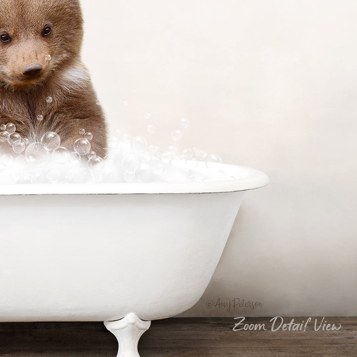 A cute brown bear cub sitting in a white bathtub filled with bubbles, creating a playful and whimsical scene.