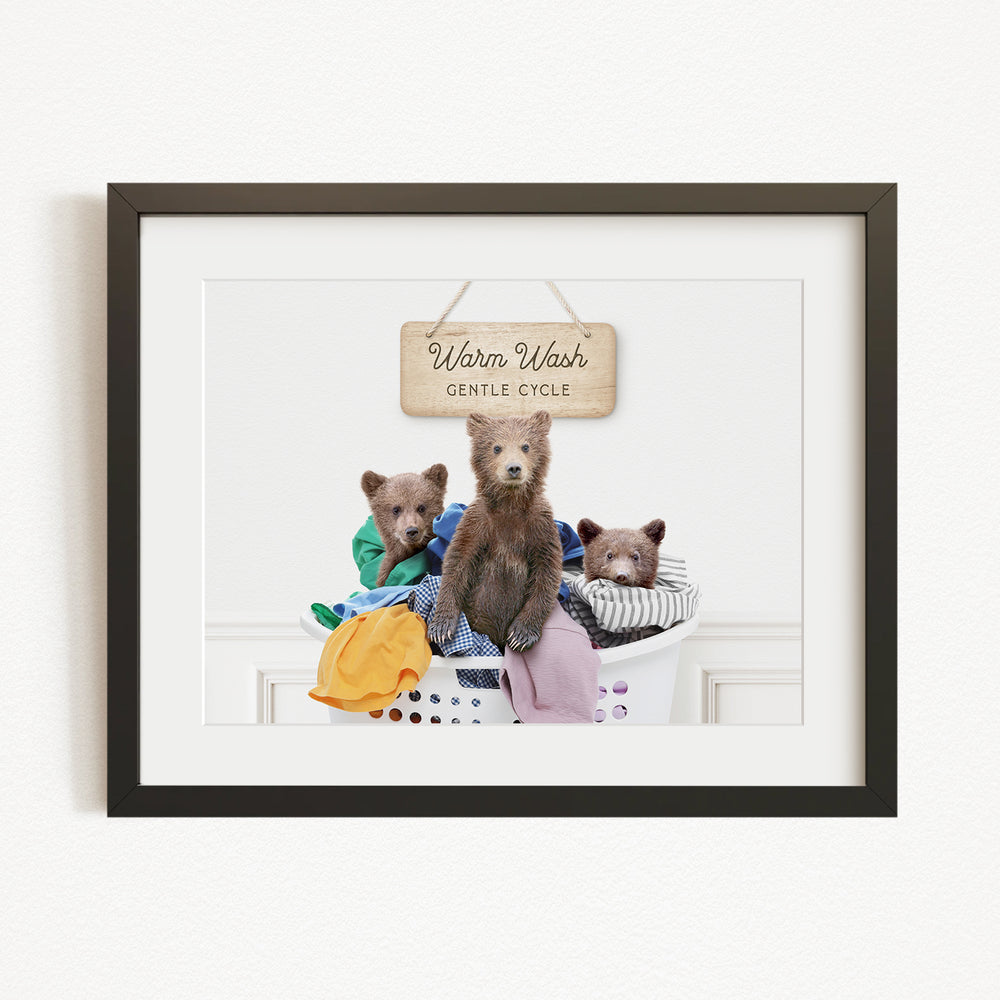 A framed image of three bears sitting in a laundry basket, with a sign above them that says "Warm Wash Gentle Cycle".