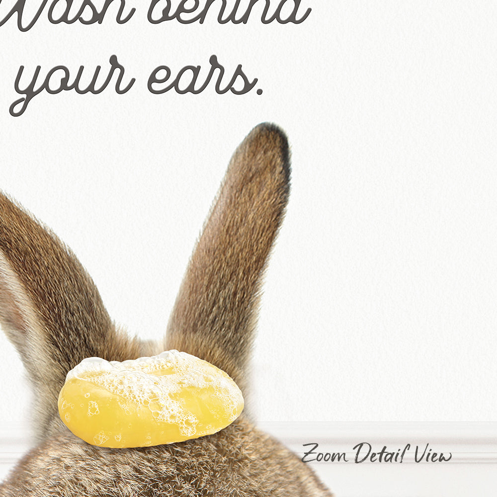 the back of a rabbit's ears with a yellow object, possibly a soap bubble or a piece of food, on it.