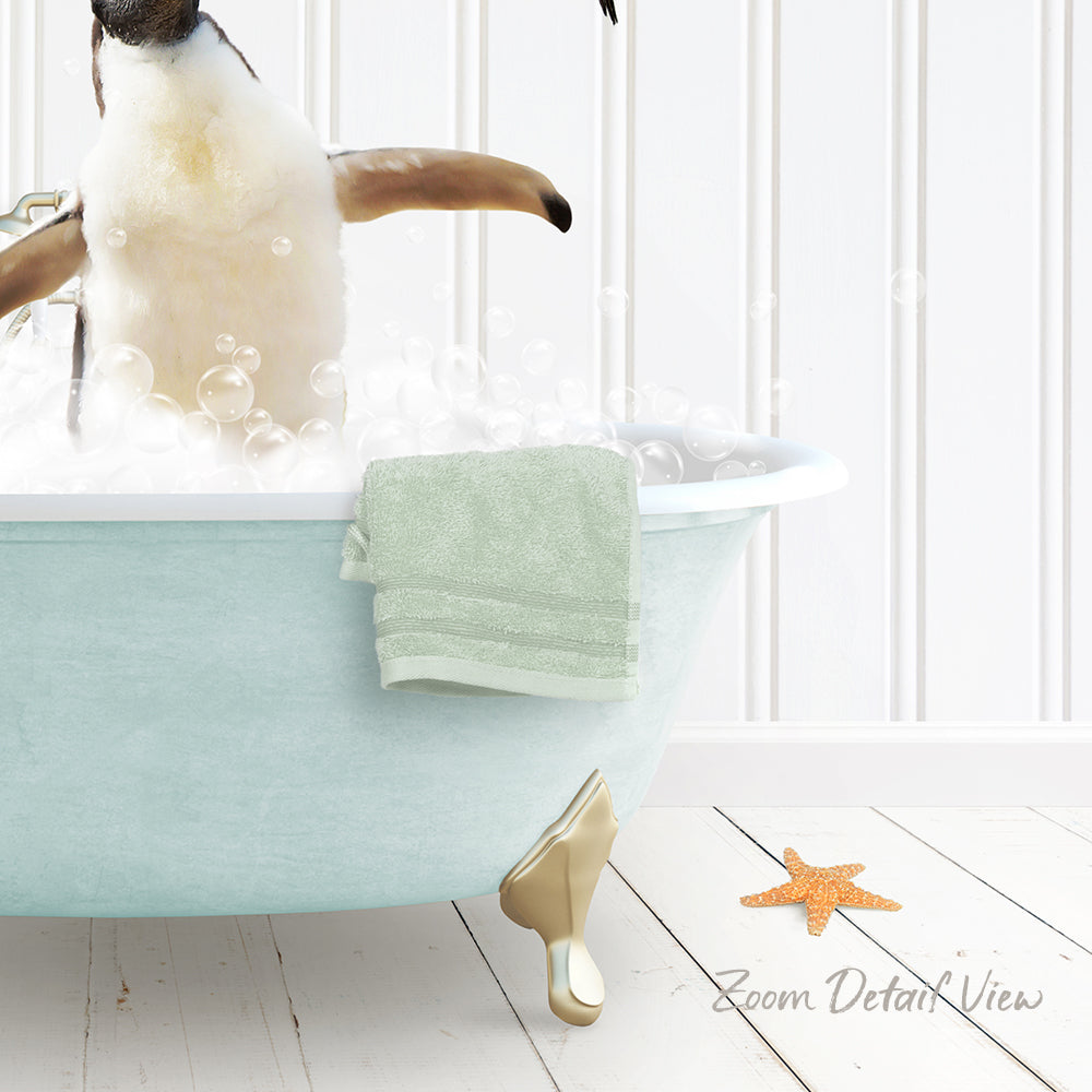 A penguin standing in a bathtub filled with bubbles, with a towel and starfish nearby.