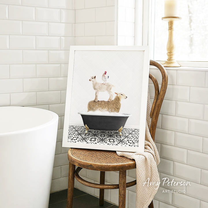 A framed image of a sheep standing on a bathtub, with a chicken perched on top, is displayed on a wooden chair in a bathroom setting.