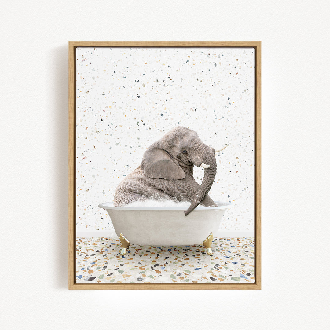 A gray elephant is sitting in a white bathtub, surrounded by a speckled tiled floor.