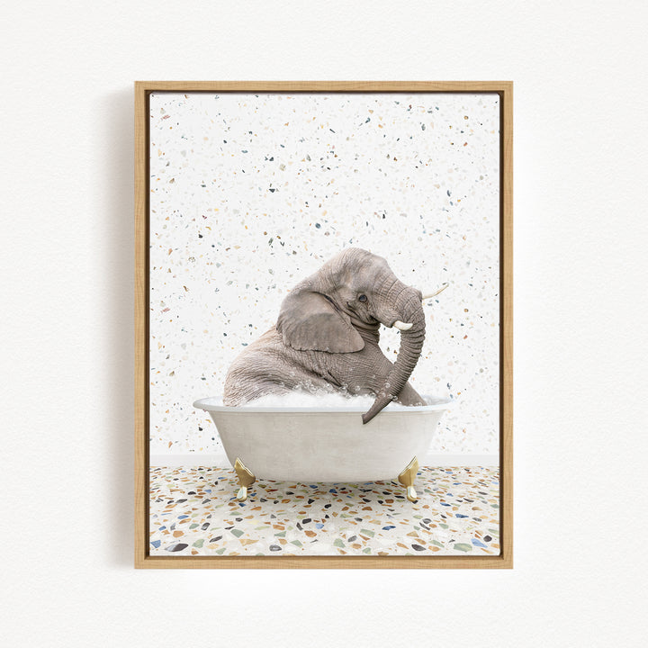 A gray elephant is sitting in a white bathtub, surrounded by a speckled tiled floor.