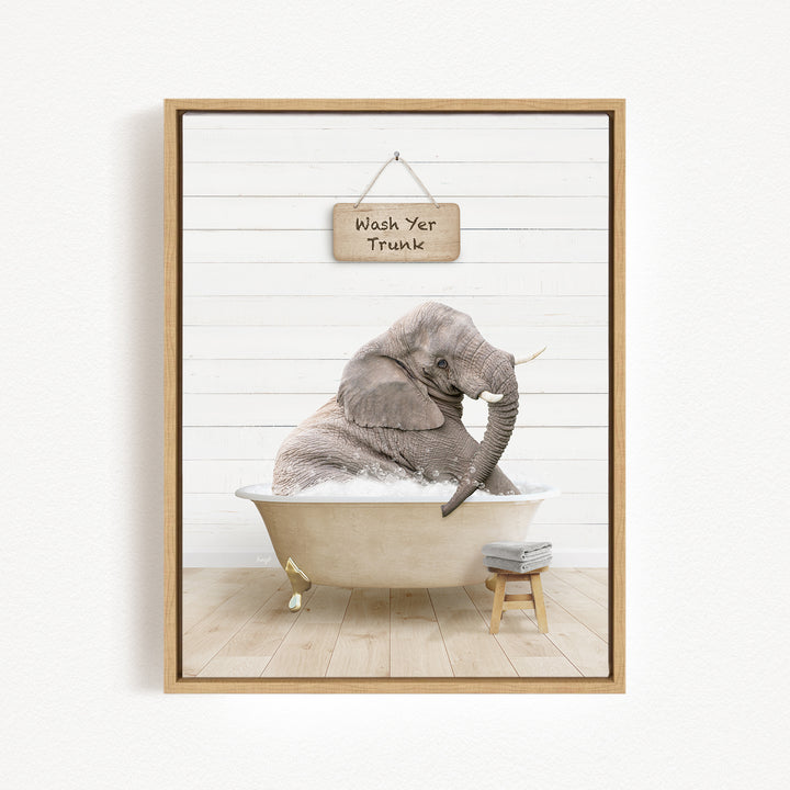 A gray elephant sitting in a bathtub, with a sign above it that says "Wash Yer Trunk".