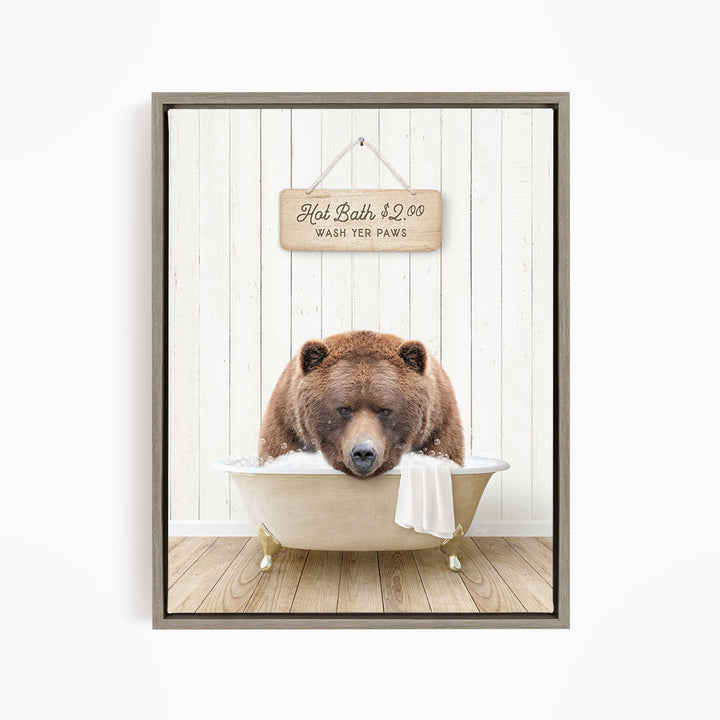 A brown bear sitting in a bathtub, with a sign above it that says "Hot Bath $2.00 WASH YOUR Paws".