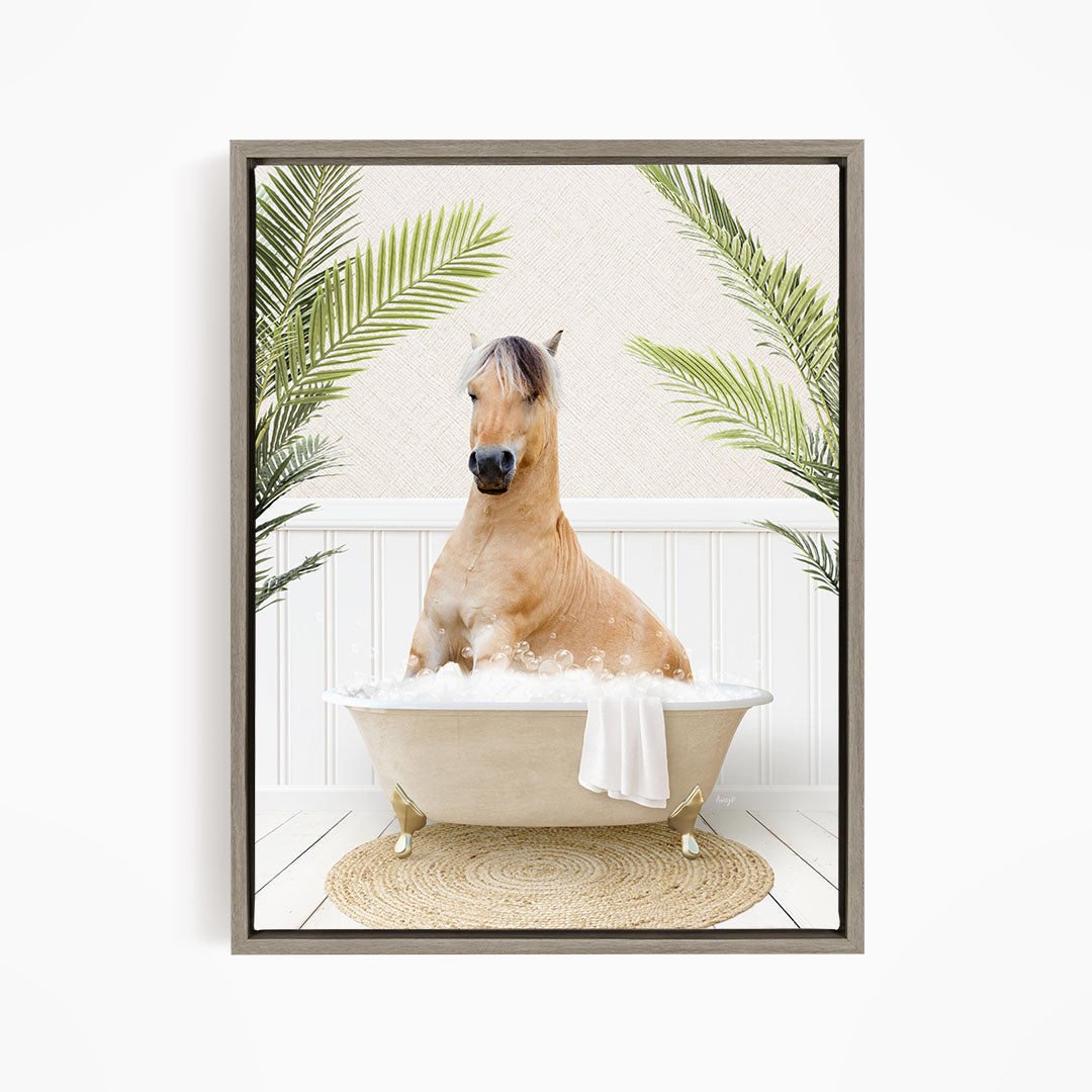 A light brown horse is sitting in a white bathtub filled with bubbles, surrounded by green palm leaves.