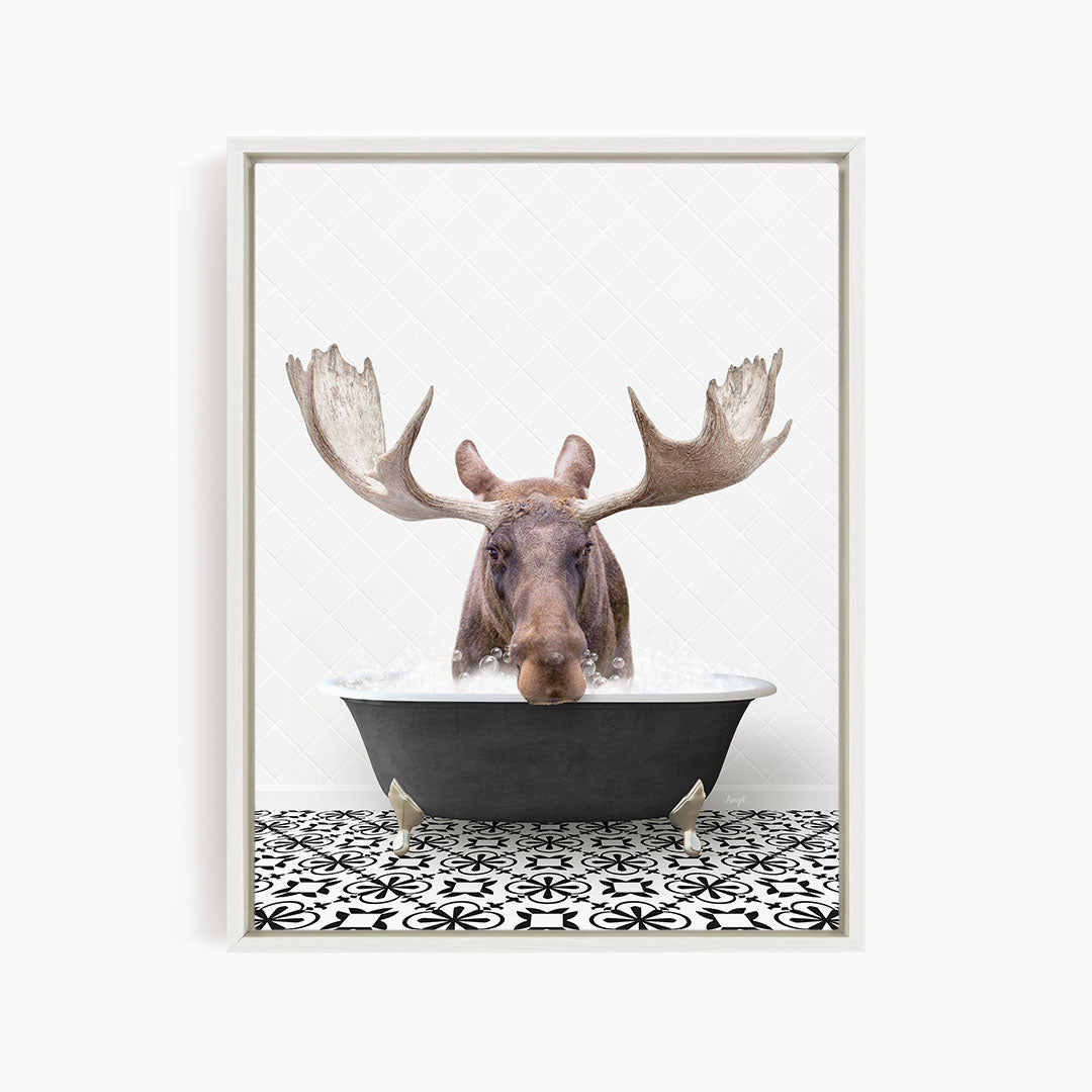 A moose with large antlers is sitting in a bathtub filled with water, creating a whimsical and humorous scene.